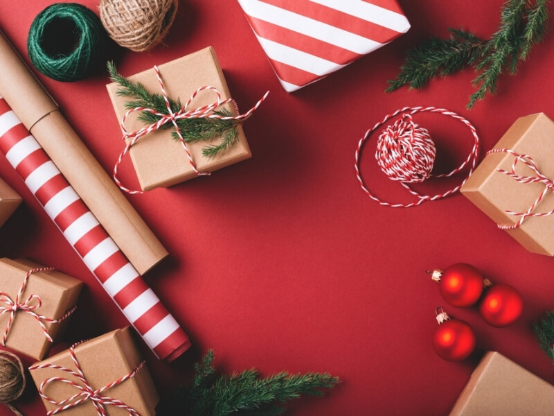 Červeno-bílý a recyklovatelný balicí papír a vánoční dárky.