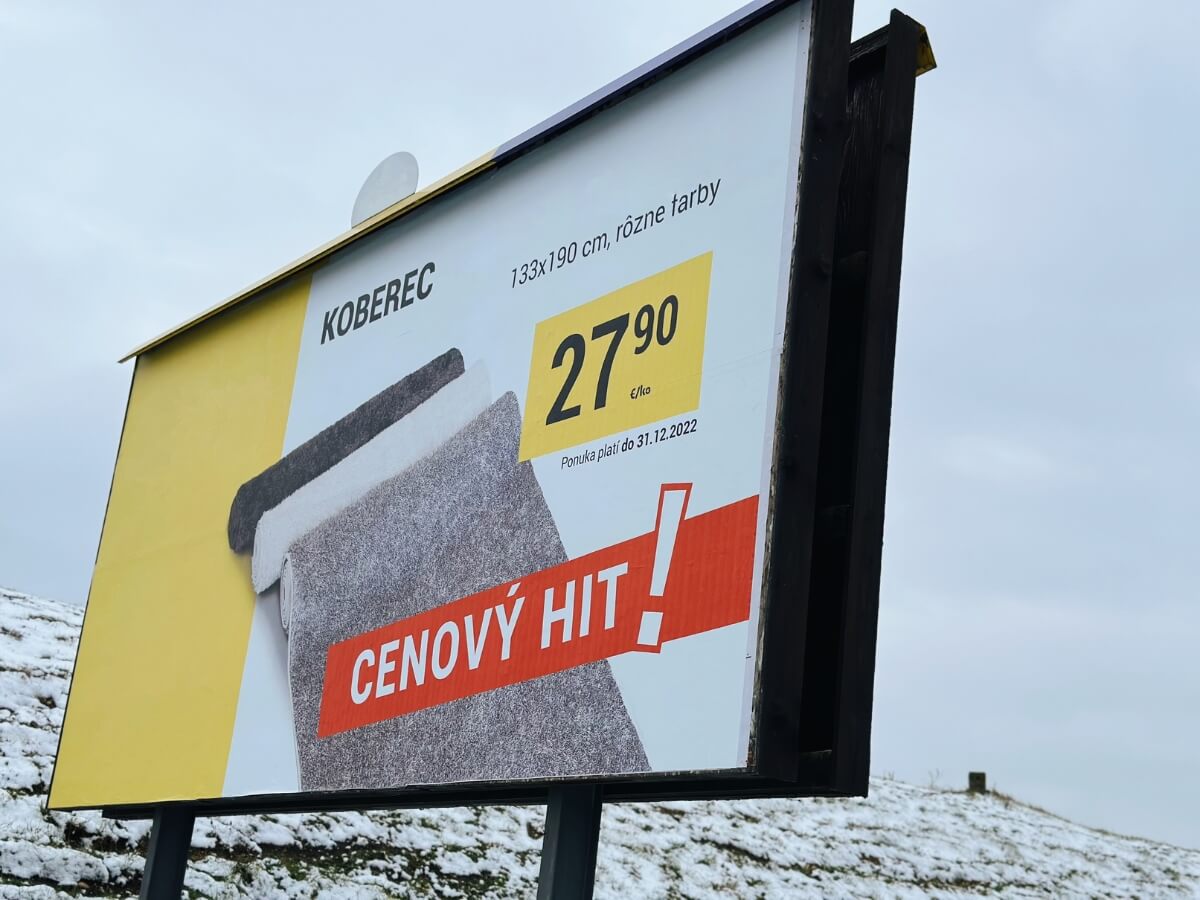 Billboard s reklamou na koberec při cestě.