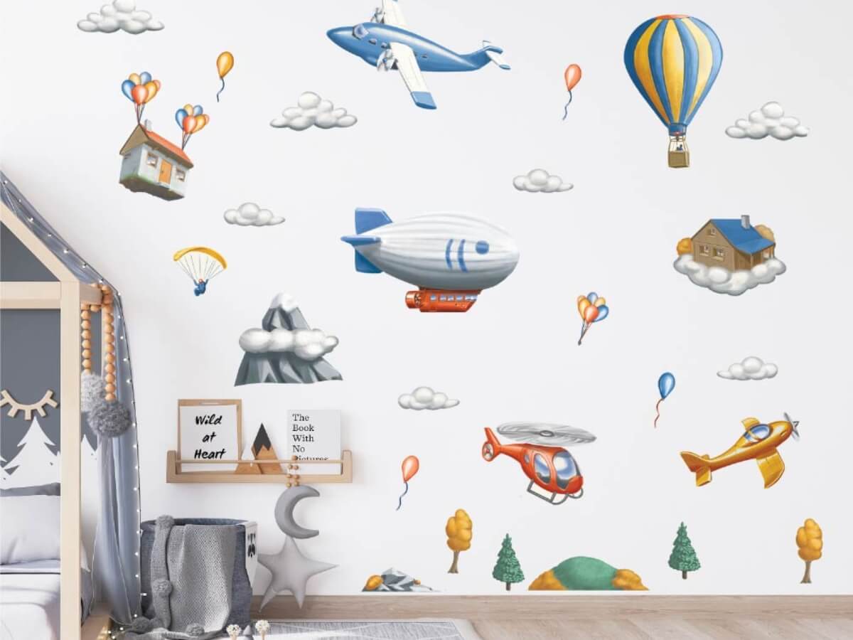 Dopravní prostředky a létající domy jako nálepky na zeď dětského pokoje.