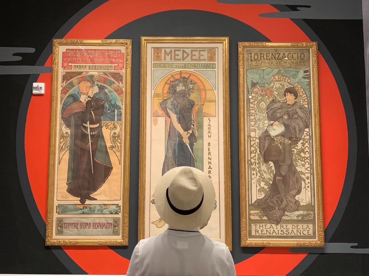 Plakáty Alfonse Muchu na výstavě plakátů v New Yorku.