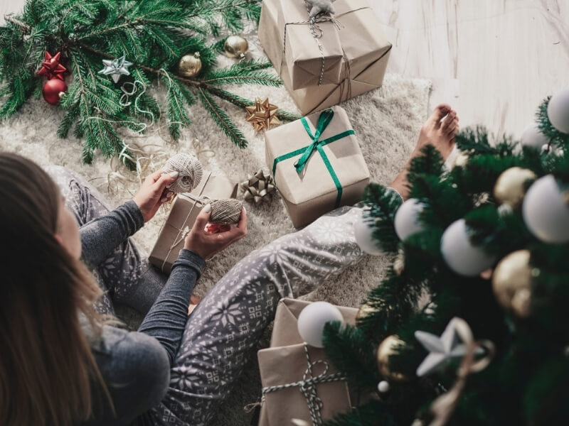 Balení vánočních dárků do recyklovaného balicího papíru.
